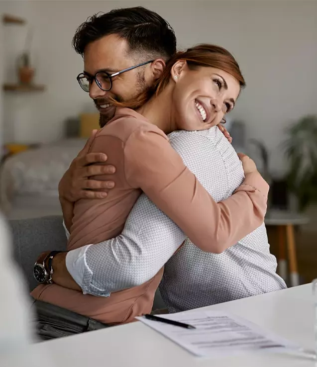 Foto de um casal se abraçando após assinar o contrato